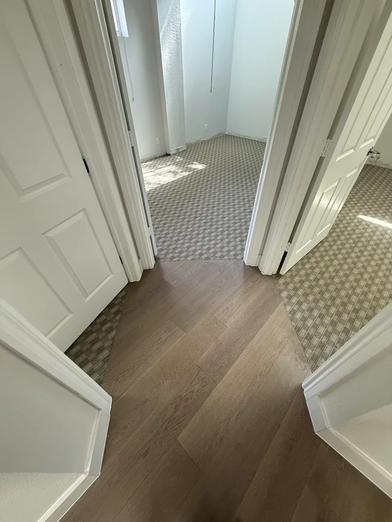 Finished corridor connecting wood-look flooring and carpet tile