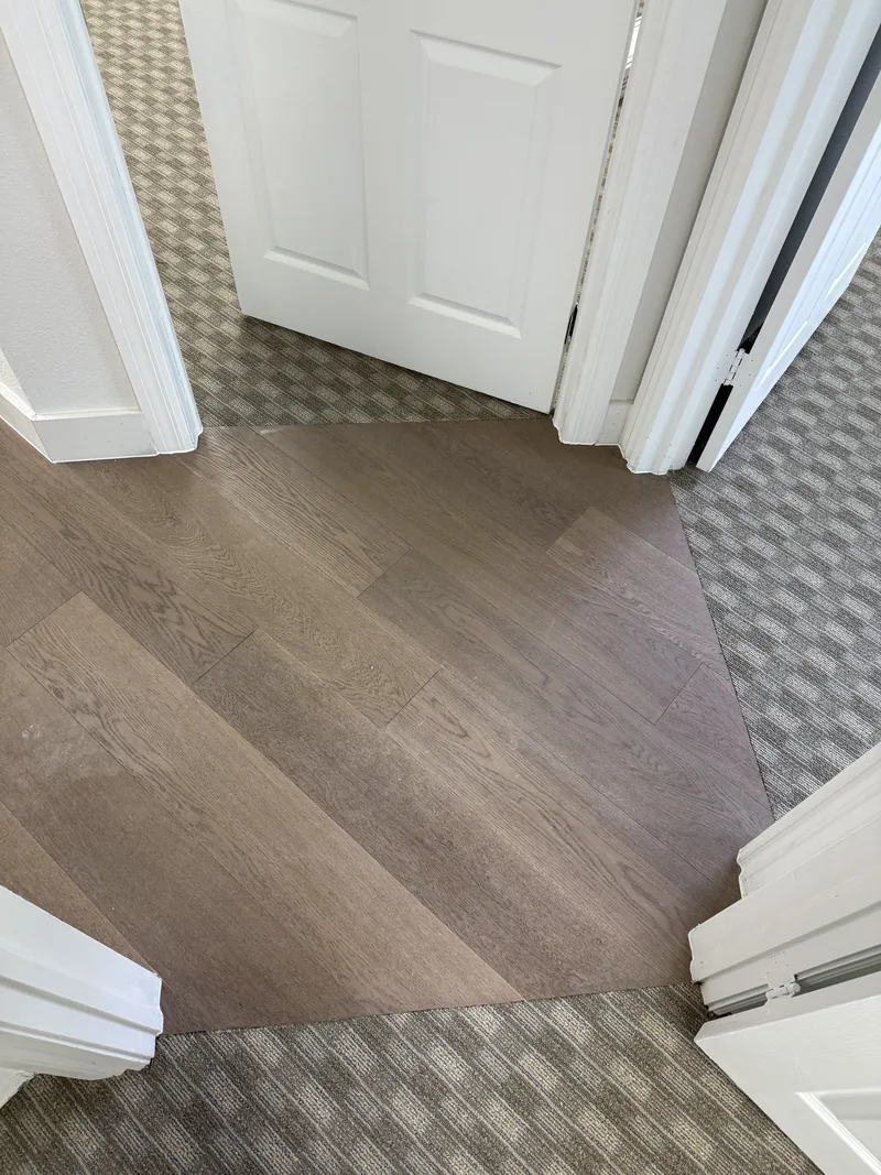 Detail where wood-look flooring meets carpet tile