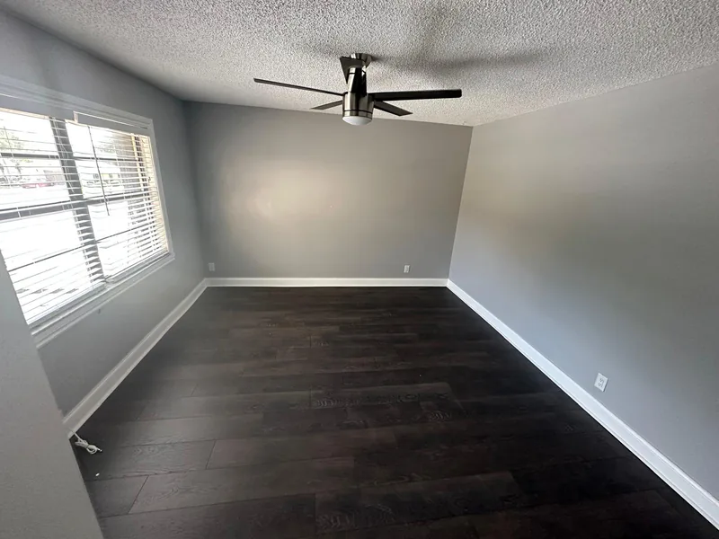 Finished corridor with dark flooring beside the stair rail