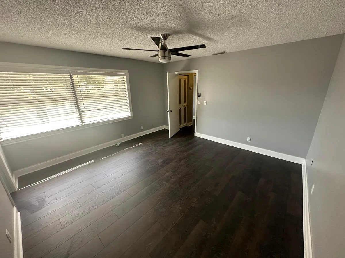 Finished room with dark-toned flooring and broad windows