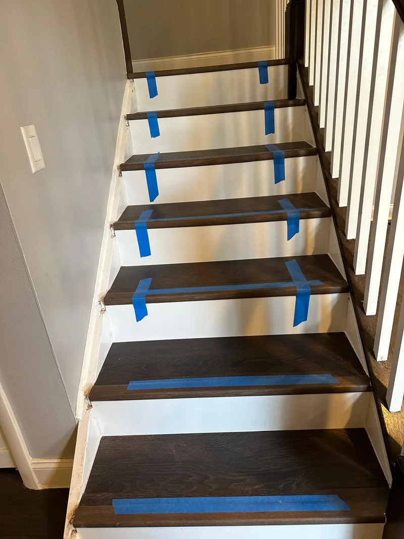 Dark stair treads documented with blue protective tape