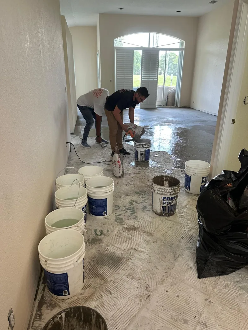 Team applying preparation material across the floor base