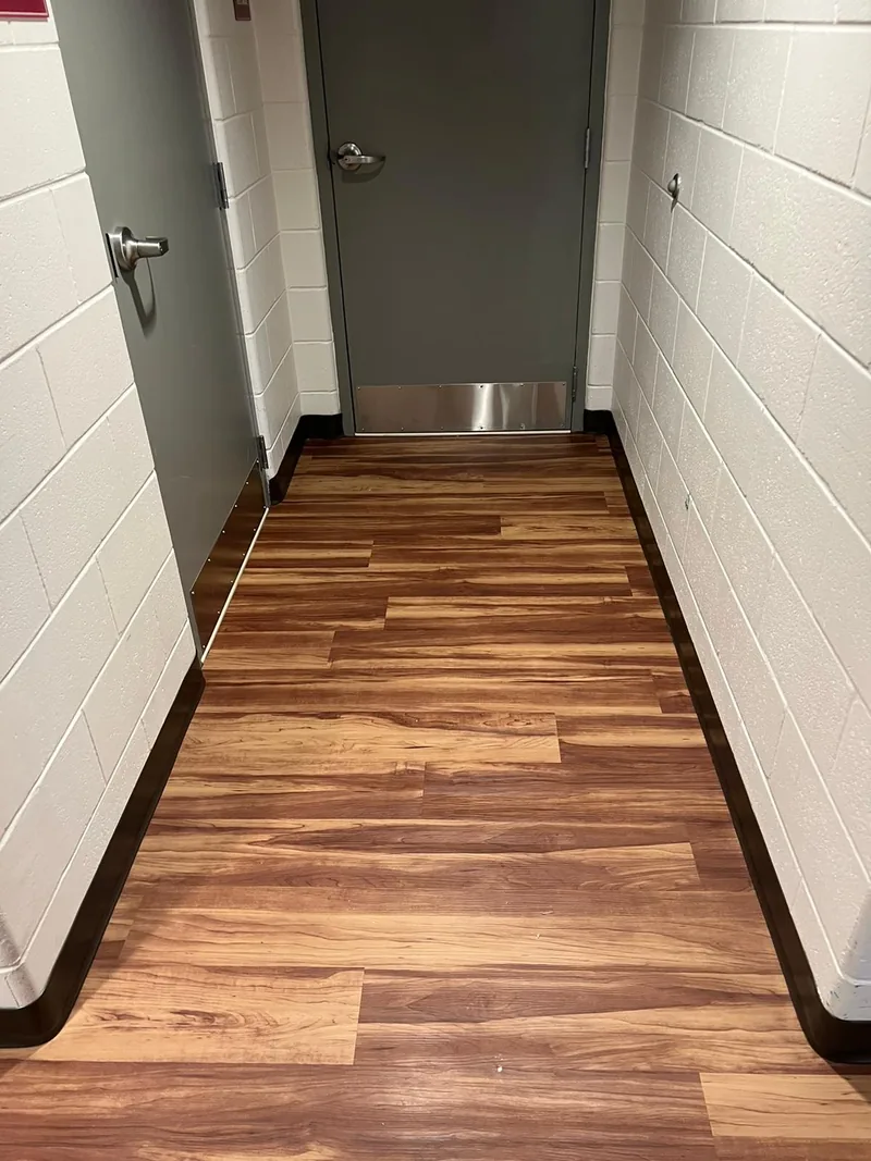 Finished bathroom with installed flooring meeting the metal door frame