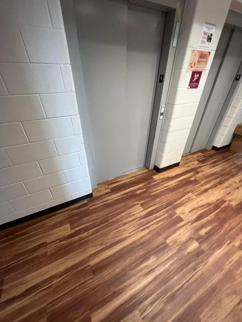 Flooring meeting the elevator threshold, cut to the frame