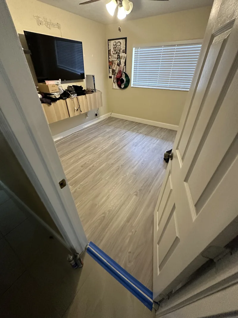 Room with wide window light falling across a light wood-look floor