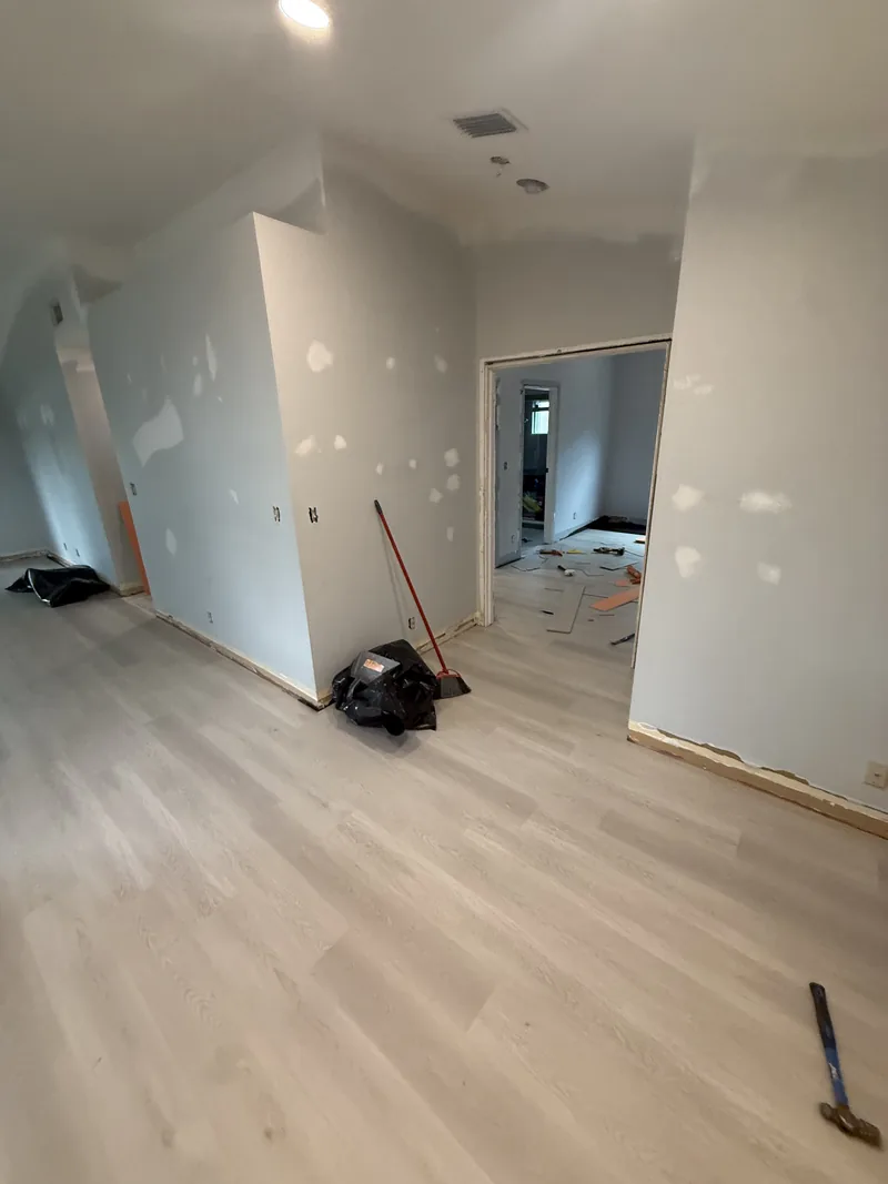 Living area with the light vinyl floor laid while the room is still open for work