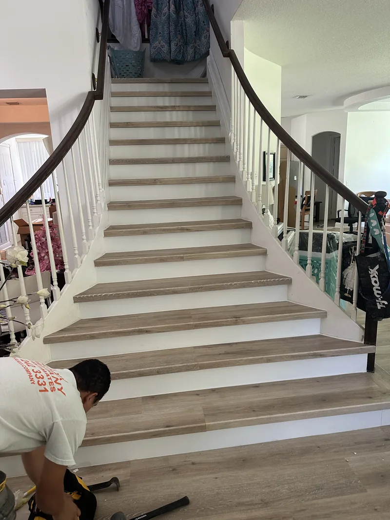 Worker continuing the flooring detail up the staircase