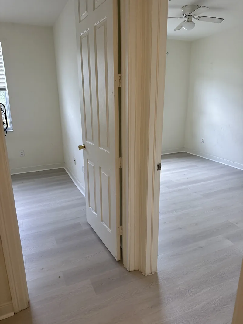 Finished bedroom with light flooring and two doorways